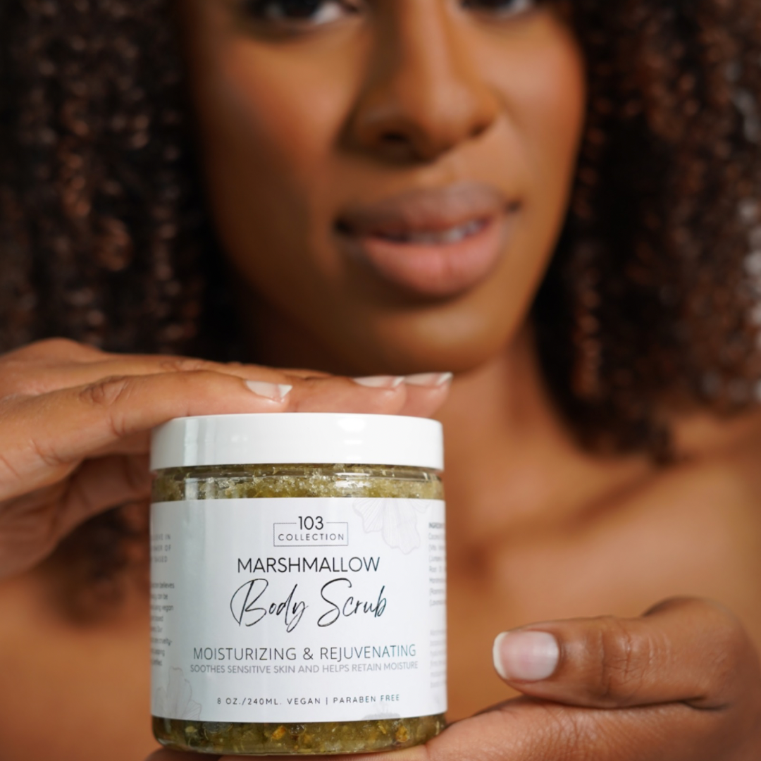 Person holding jar of Vegan Marshmallow Body Scrub for sensitive skin, enriched with organic sugar cane and marshmallow root.