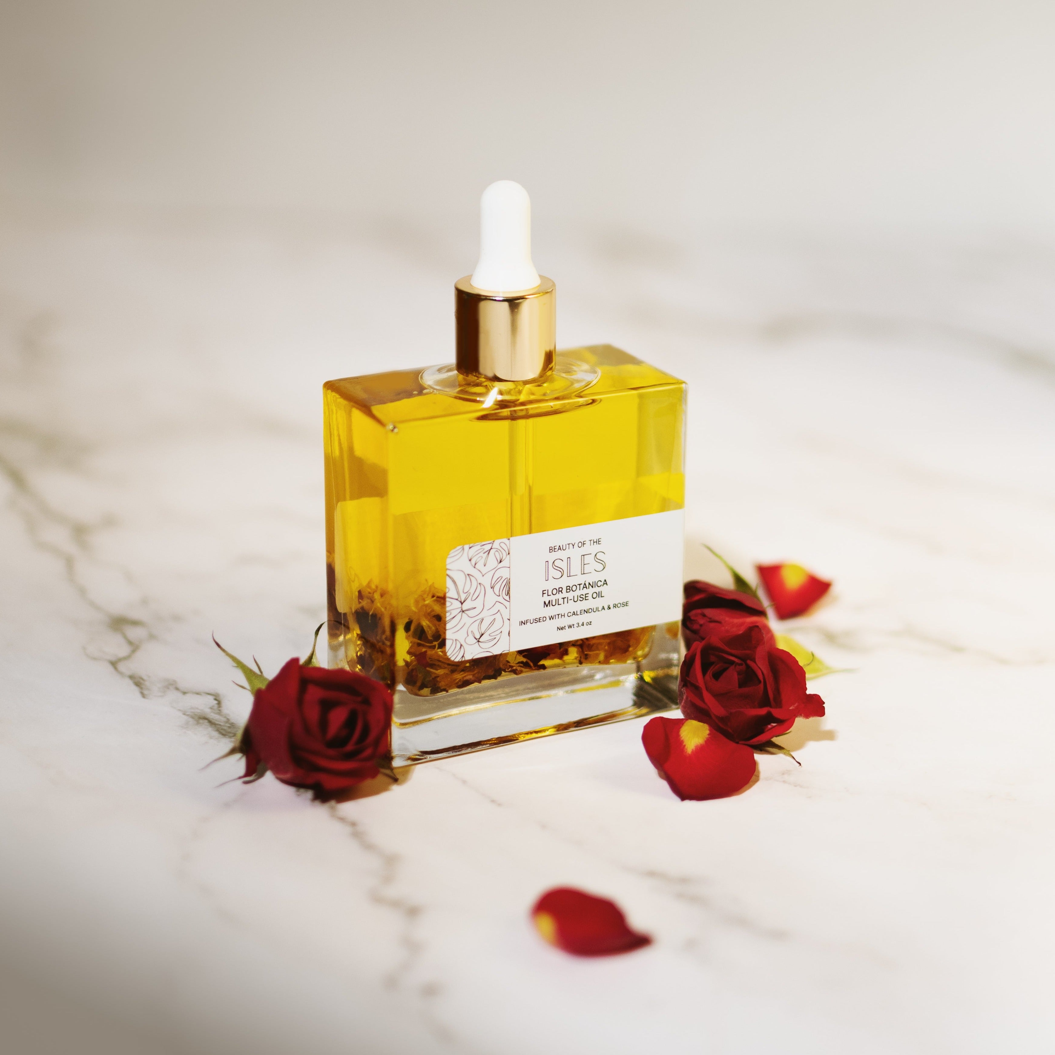 Flor Botánica Multi-Use Oil with rose and calendula on marble, luxurious skin and hair nourishment.