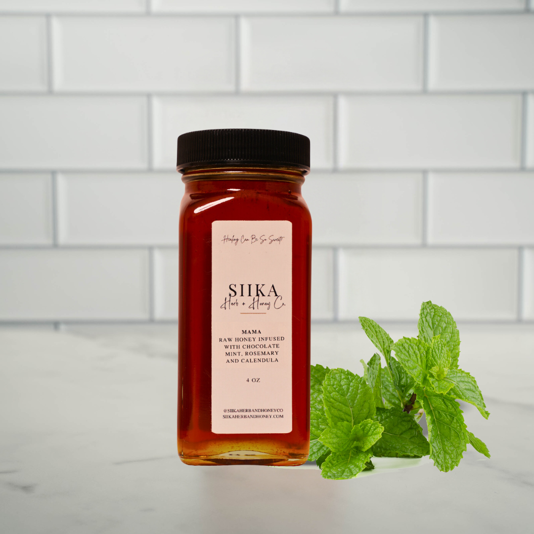 Mama Mint & Rosemary Honey jar with fresh mint leaves in a kitchen setting.