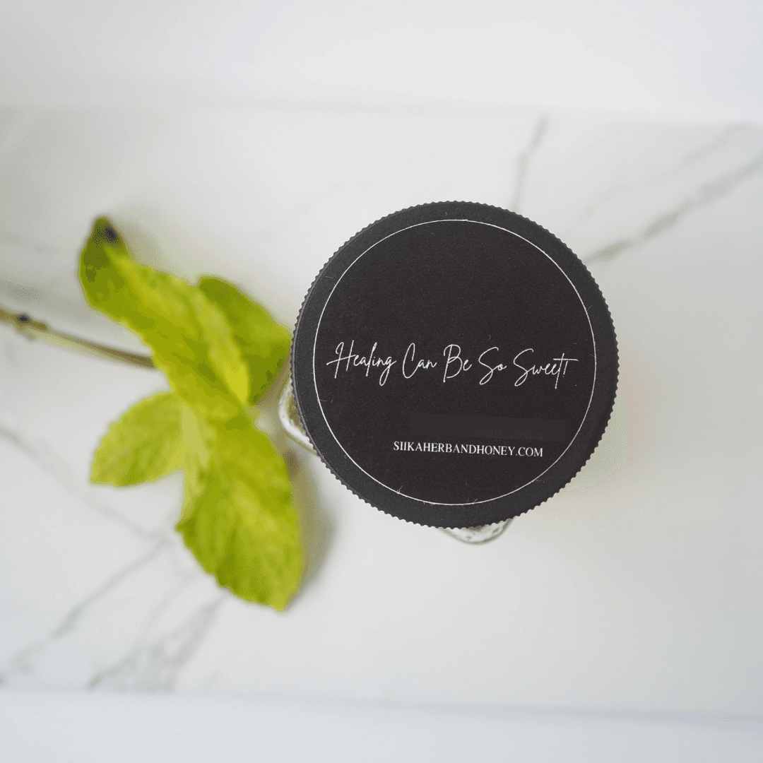 Top view of Mama Mint & Rosemary Honey jar with green leaves, highlighting healing benefits and brand website.