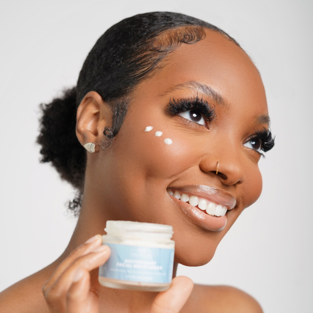 Smiling woman applying Vegan Antioxidant Facial Moisturizer, showcasing its lightweight, nourishing formula enriched with hyaluronic acid and antioxidants.