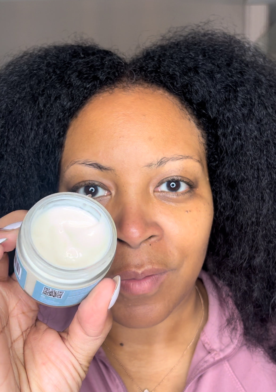 Person holding a jar of face cream from the Vegan Antioxidant Radiant Glow Deluxe Bundle.