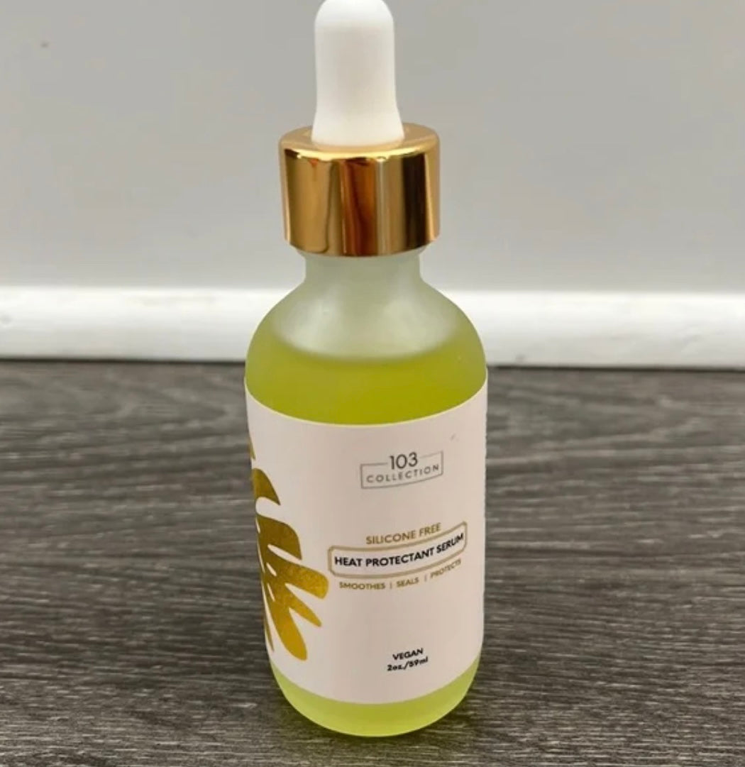 Vegan Heat Protectant Serum bottle on wooden surface promoting cruelty-free, lightweight formula for styling protection and shine boost.