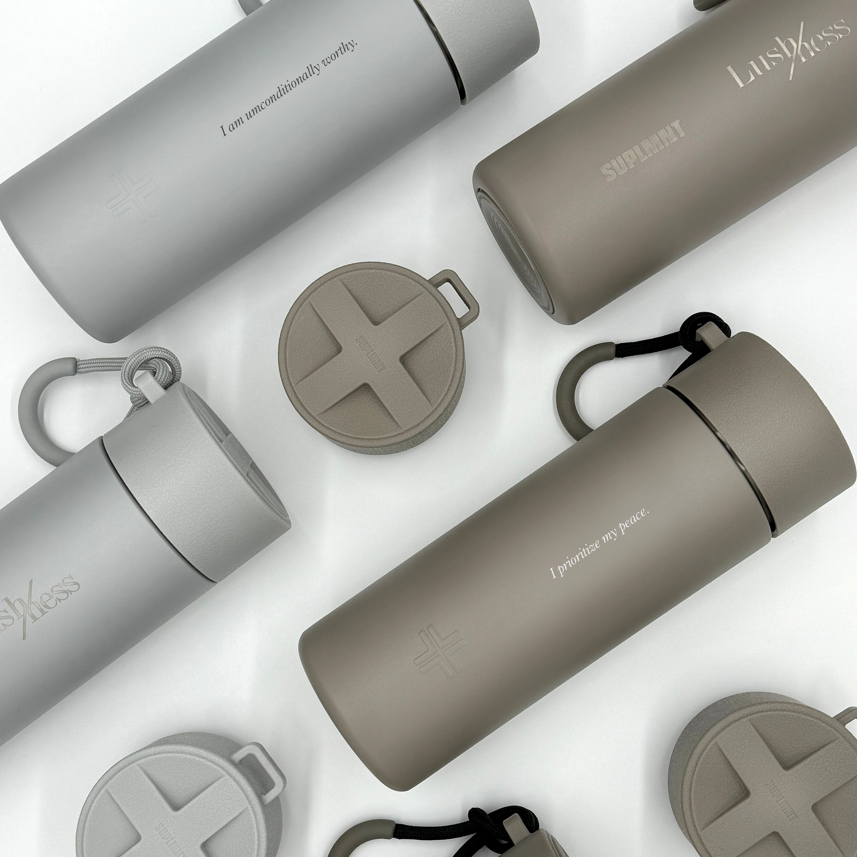 Earth-toned stainless steel affirmation water bottles by Suplmnt x Lushness, featuring "I prioritize my peace" mantra, 24 oz, limited edition.