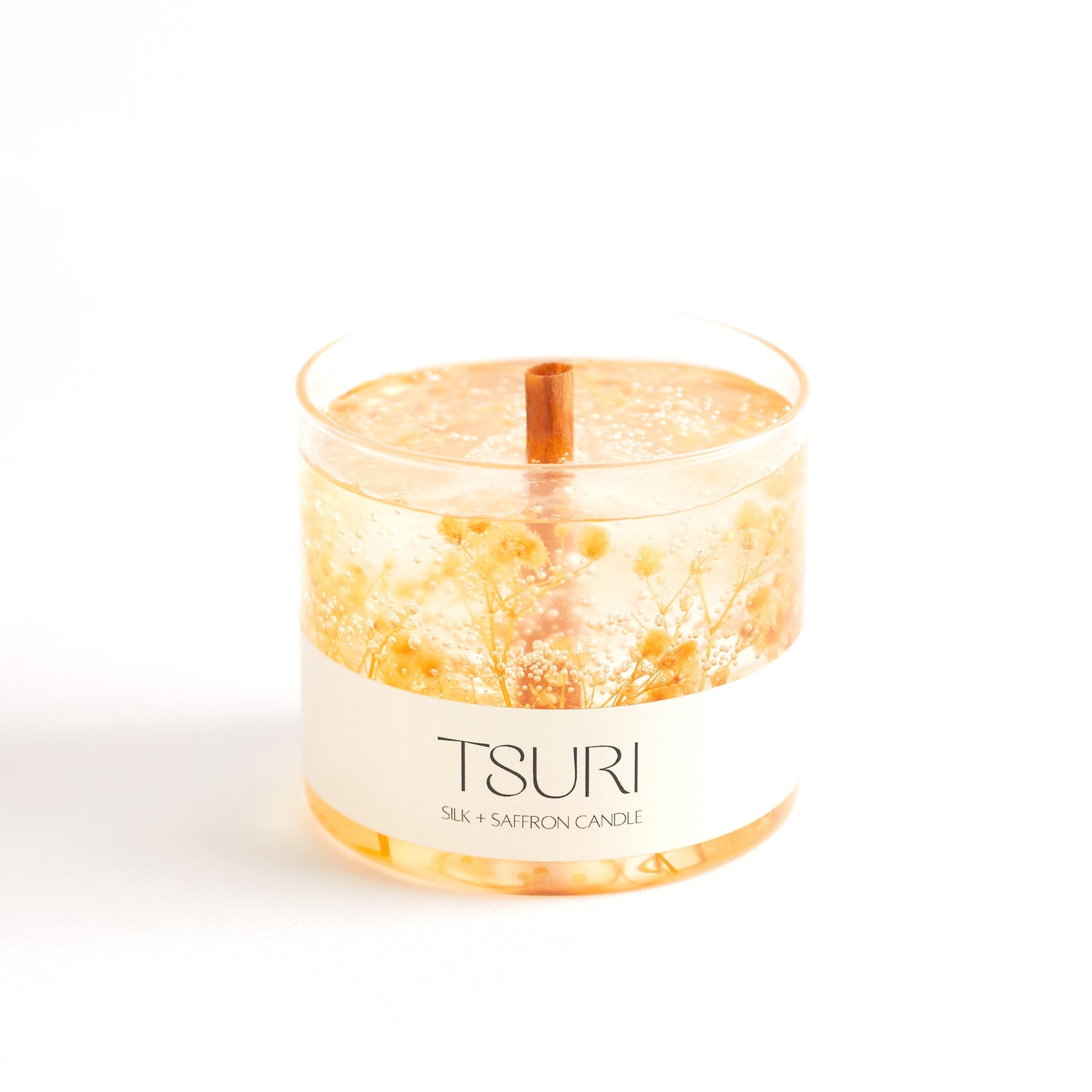 Silk + Saffron Signature Scented Candle with wooden wick and organic botanicals, creating a warm, exotic ambiance.