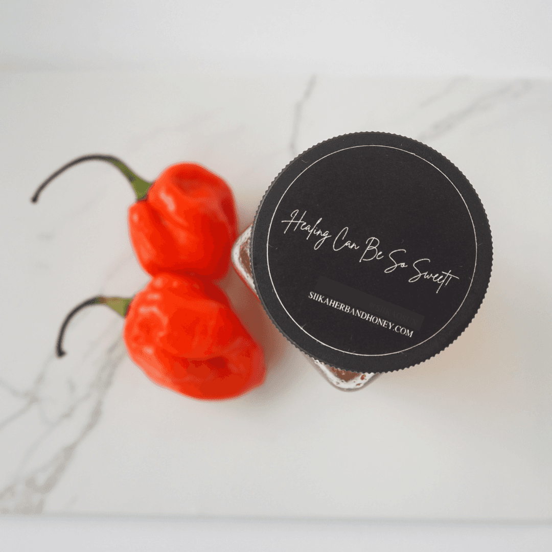 Jar of Freddie Sweet Chili Honey with pimento peppers on marble surface