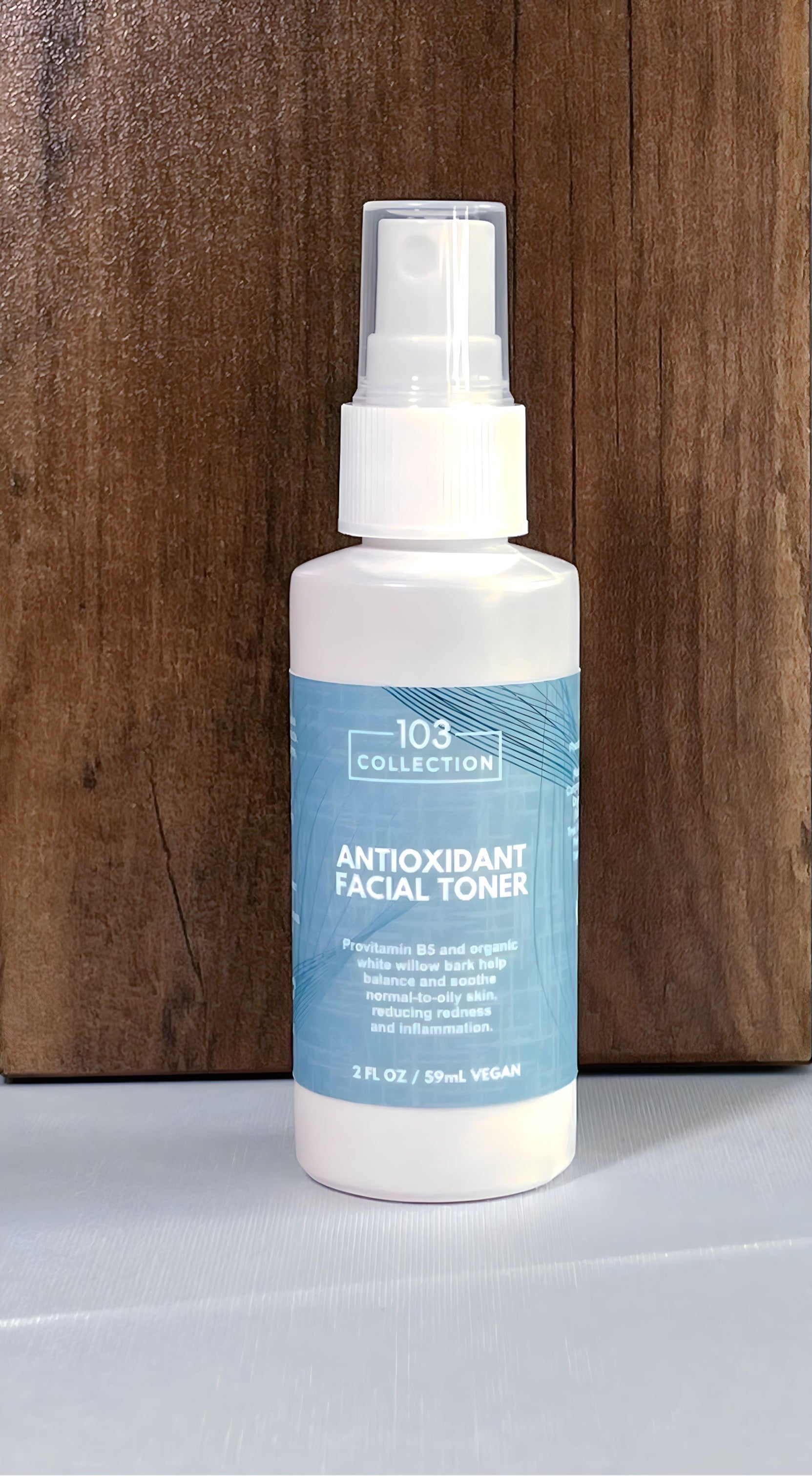 Alt Tag: Vegan antioxidant facial toner for sensitive skin, 103 Collection, cruelty-free skincare, 2 fl oz bottle on wooden background