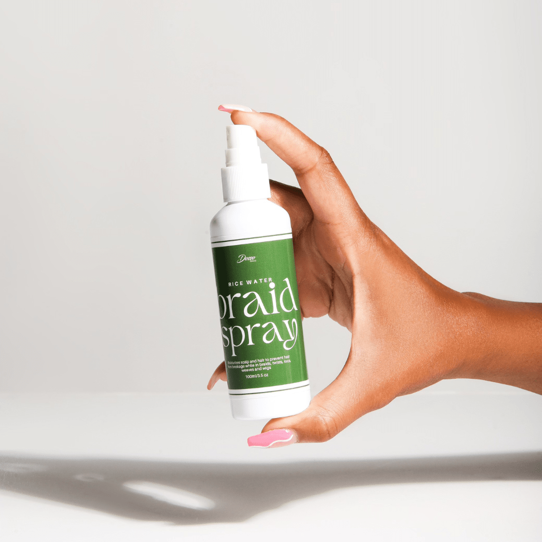 Hand holding Rice Water Braid Spray bottle, designed for moisturizing and strengthening braids, twists, and locs.