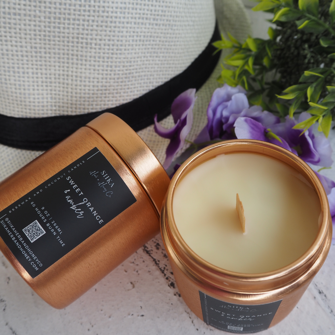 SIIKA Sweet Orange & Amber beeswax candle in copper tin, featuring a wood wick. Spiced orange and amber aroma with hat and flowers.
